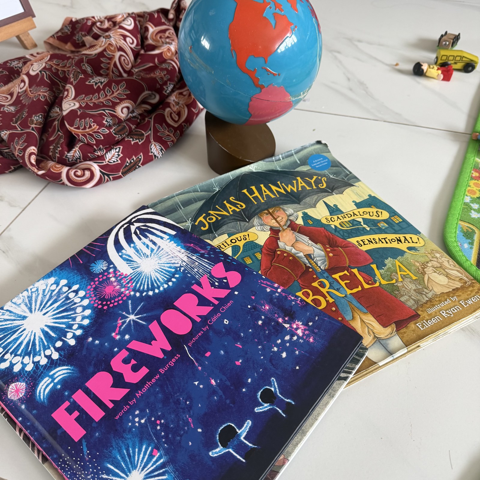 A globe beside the picture books Fireworks and Jonas Hanway’s Umbrella